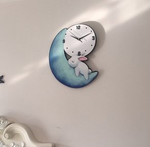 Houten kinderklok met slapend konijn